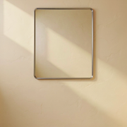 Brushed Nickel Rounded Rectangle Bathroom Mirror against a cream limewash wall with warm natural side light