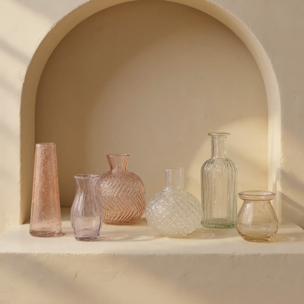 Assorted Glass Bud Vase Set in a cream plaster niche with warm natural side light