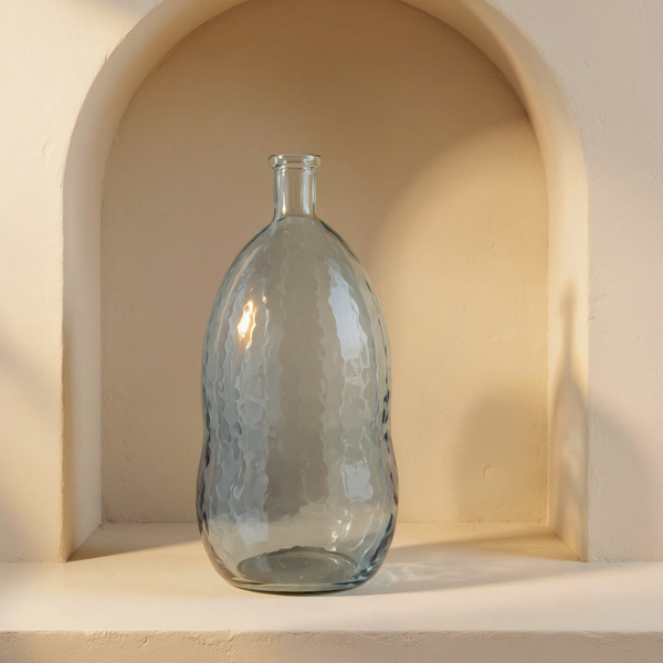 Smoke Handmade Hammered Glass Vase in a cream plaster niche with warm natural side light