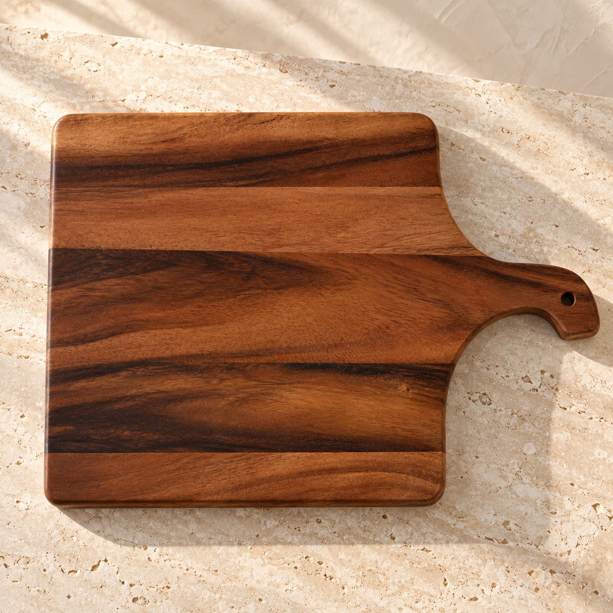 Acacia Wood Handle Cutting Board — Small - 12" on a sunlit pale travertine counter