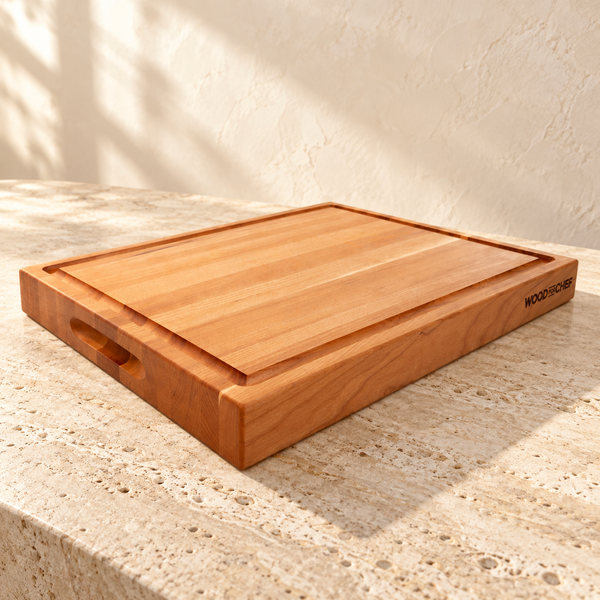 Edge-Grain Hardwood Reversible Cutting Board — Cherry Wood / 20x16x1.5 in on a sunlit pale travertine counter