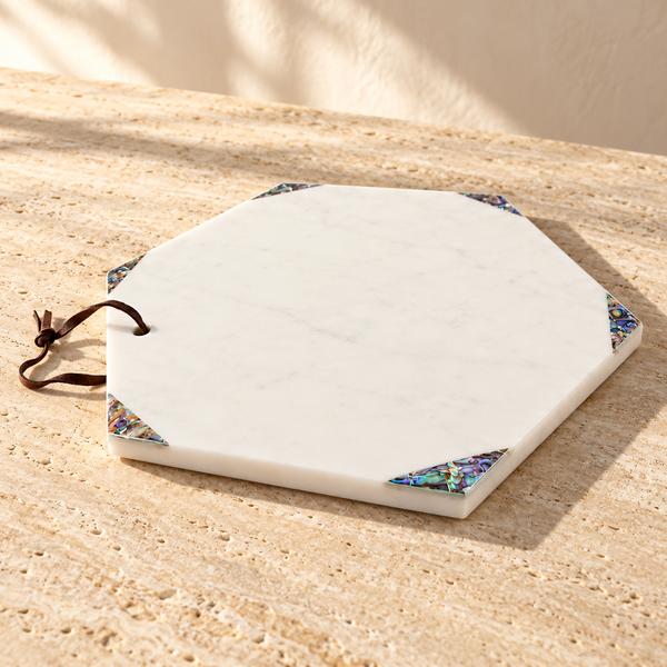 Hexagonal Marble Mother of Pearl Board on a sunlit pale travertine counter