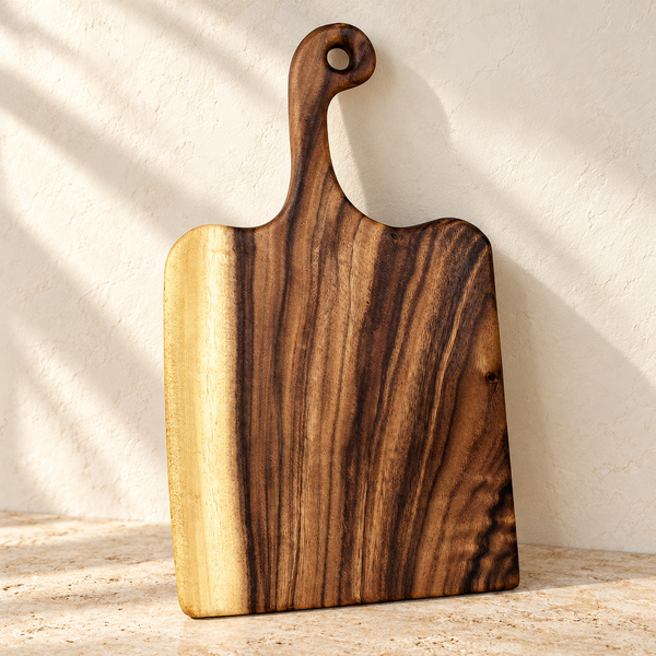 Live Edge Walnut Handled Cutting Board — Blank Board on a sunlit pale travertine counter