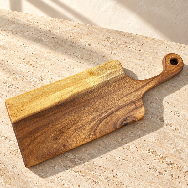 Live Edge Walnut Handled Cutting Board — Blank Board on a sunlit pale travertine counter