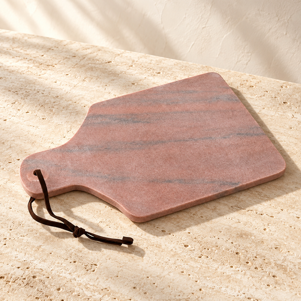 Rose Marble Paddle Serving Board on a sunlit pale travertine counter