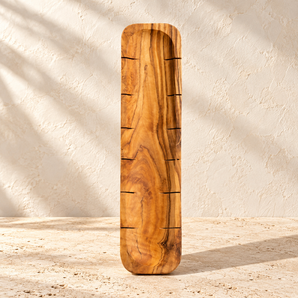 Scored Olive Wood Bread Board on a sunlit pale travertine counter