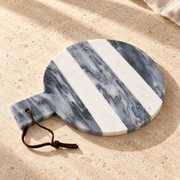 Striped Marble Round Cheese Board on a sunlit pale travertine counter