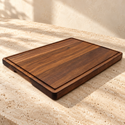 Thick-Cut Walnut Wood Cutting Board — Groove & Handles / 20" x 15" x 1.25" on a sunlit pale travertine counter
