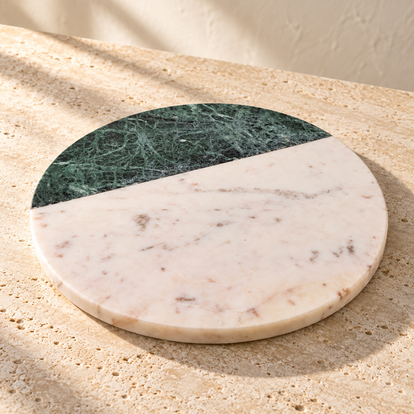 Two-Tone Marble Round Serving Board on a sunlit pale travertine counter