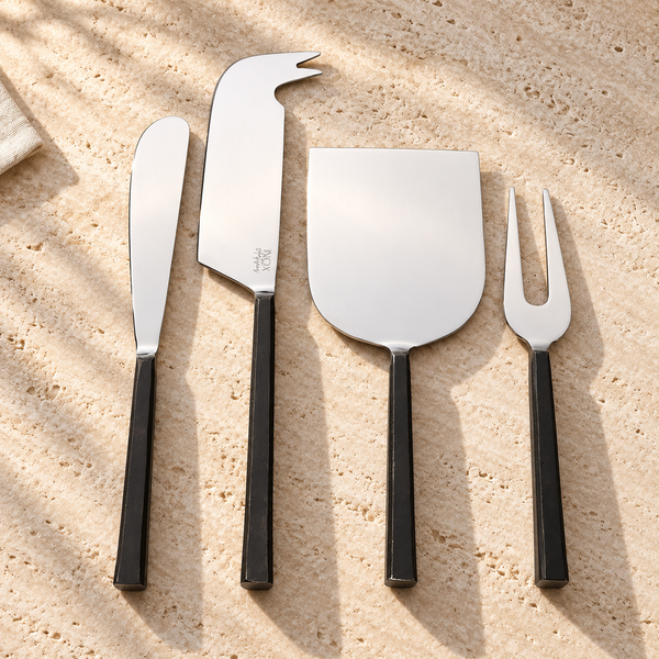 Black Handle Stainless Steel Cheese Knife Set on a sunlit pale travertine counter