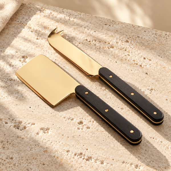 Brass-Finish Steel Cheese Tool Set on a sunlit pale travertine counter