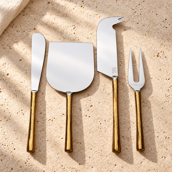 Gold-Handle Stainless Steel Cheese Knife Set on a sunlit pale travertine counter