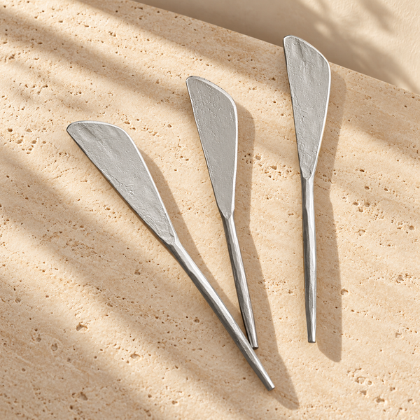 Hammered Pewter Spreader Knife Set on a sunlit pale travertine counter
