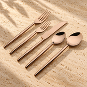 PVD-Coated Stainless Steel Flatware Set on a sunlit pale travertine counter