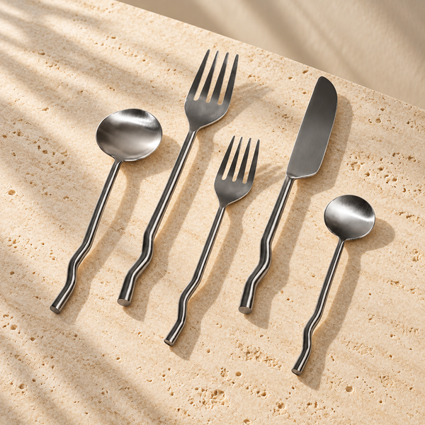 20-Piece Stainless Steel Flatware Set on a sunlit pale travertine counter