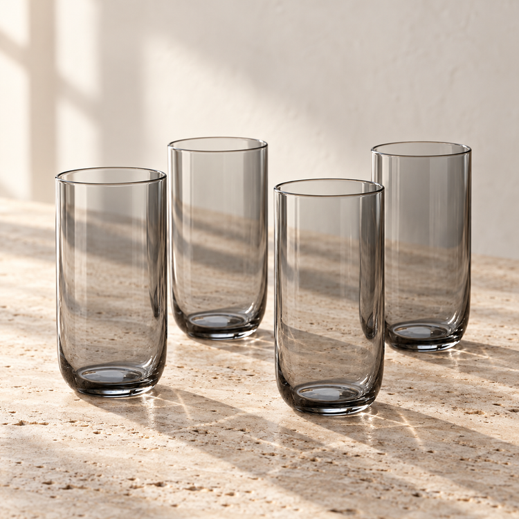 Smoke-Tinted Glass Tumbler Set empty on honed travertine in warm side light