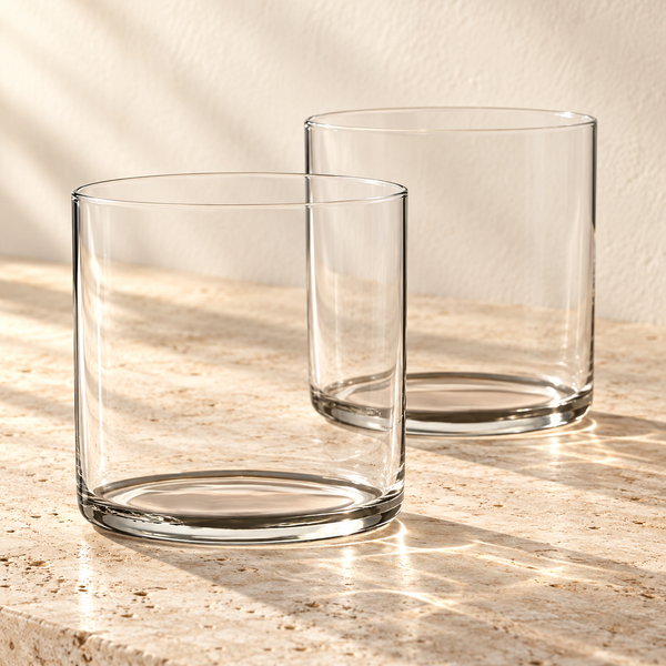 Hand-Blown Crystal Rocks Glasses empty on honed travertine in warm side light