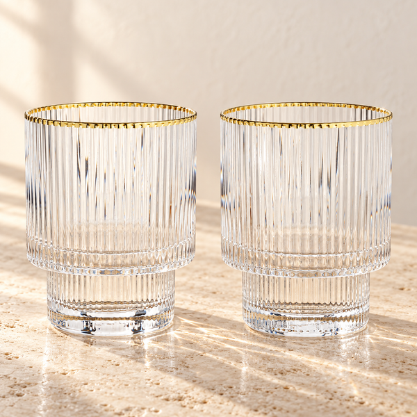 Ribbed Crystal Tumbler Set empty on honed travertine in warm side light