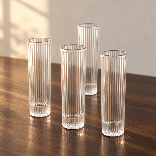 Ribbed Clear Champagne Flute Set empty on an espresso walnut bar top in warm side light