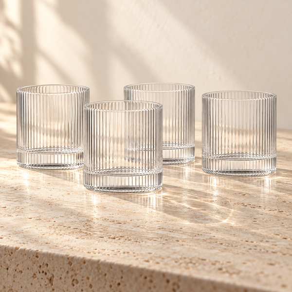 Ribbed Clear Glass Tumbler Set empty on honed travertine in warm side light