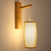 Woven Bamboo Wall Sconce Lamp illuminated against cream plaster
