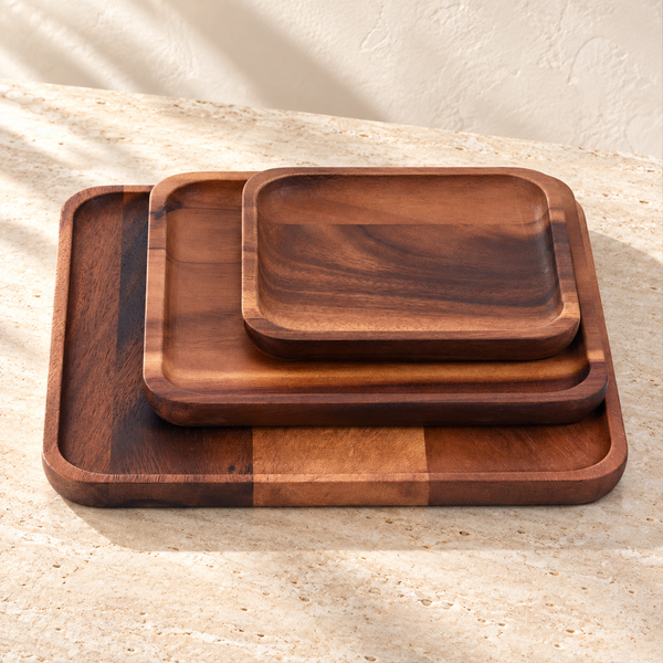 Acacia Wood Serving Plate Set on a sunlit pale travertine counter