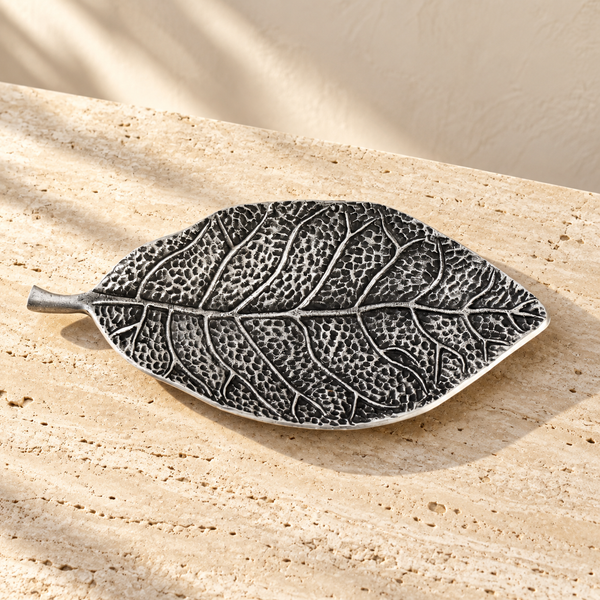 Antiqued Metal Leaf Catchall Tray on a sunlit pale travertine counter