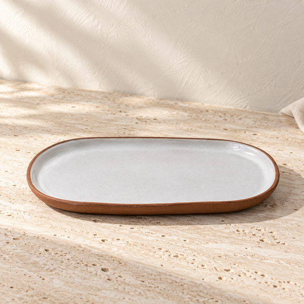 Glazed Ceramic Oval Serving Platter on a sunlit pale travertine counter