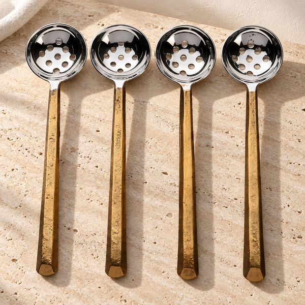 Gold-Finish Perforated Olive Spoon Set on a sunlit pale travertine counter