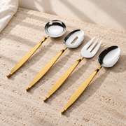 Gold-Handle Stainless Hostess Serving Set on a sunlit pale travertine counter