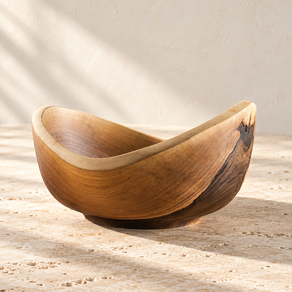Hand-Carved Walnut Wood Bowl on a sunlit pale travertine counter