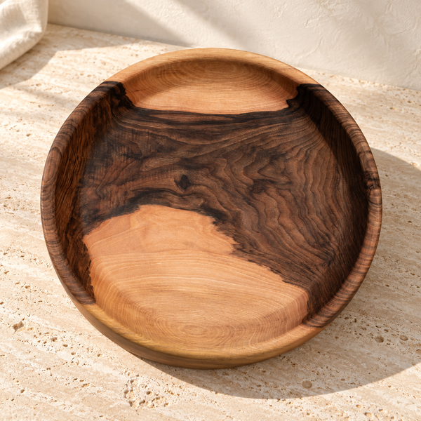 Live-Edge Walnut Round Tray on a sunlit pale travertine counter