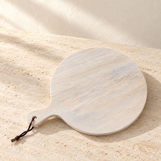 Mango Wood Round Serving Board on a sunlit pale travertine counter