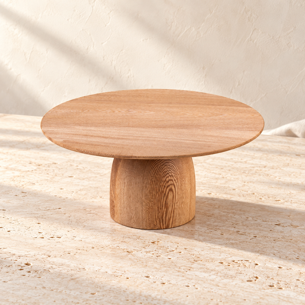 Hand-Carved Rosa Morada Wood Cake Stand on a sunlit pale travertine counter