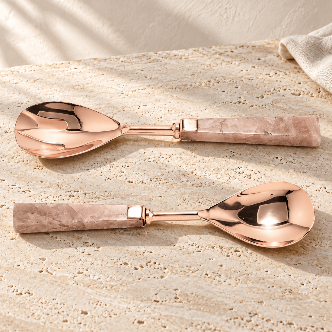 Rose Quartz Handle Salad Server Set on a sunlit pale travertine counter