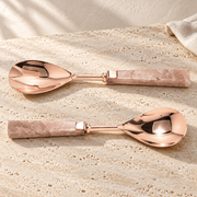 Rose Quartz Handle Salad Server Set on a sunlit pale travertine counter