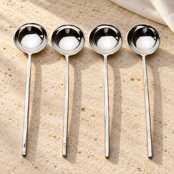 Polished Stainless Steel Sugar Spoon Set on a sunlit pale travertine counter