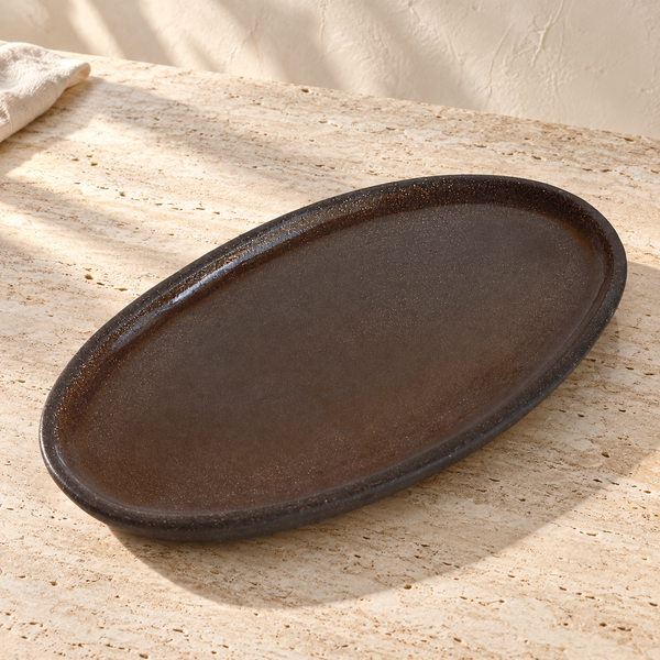 Grit-Glazed Stoneware Oval Platter on a sunlit pale travertine counter