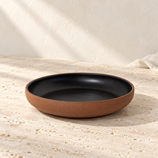 Terracotta Clay Coupe Serving Bowl on a sunlit pale travertine counter