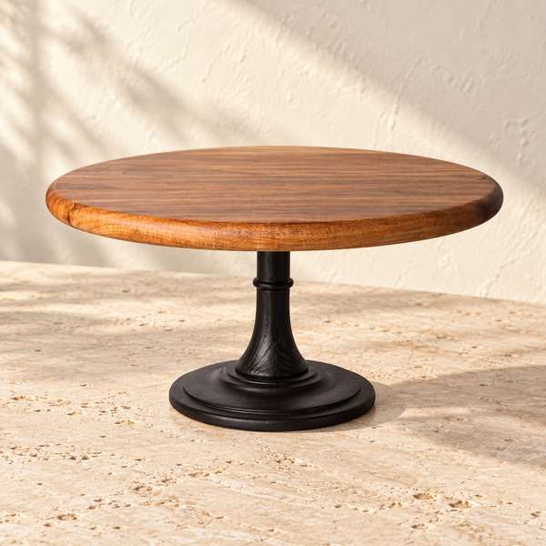Dark Wood-Grain Pedestal Cake Stand on a sunlit pale travertine counter