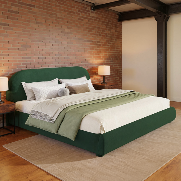 Curved Velvet Upholstered Bed Frame with ivory bedding in a brick and steel loft bedroom with a flat oatmeal rug.