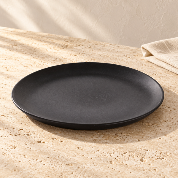 Matte Black Stoneware Dinner Plate Set on a sunlit travertine counter