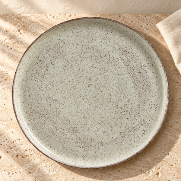 Reactive Glaze Dinner Plate Set in Pistache on a sunlit travertine counter