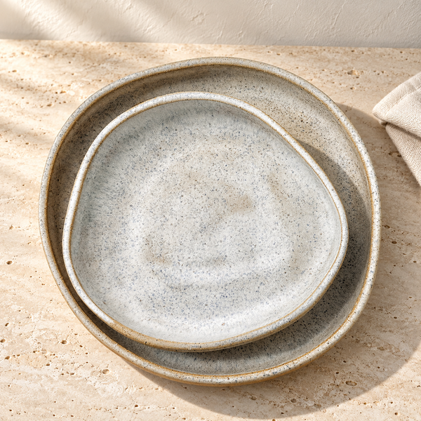 Speckled Ceramic Plate Set on a sunlit travertine counter