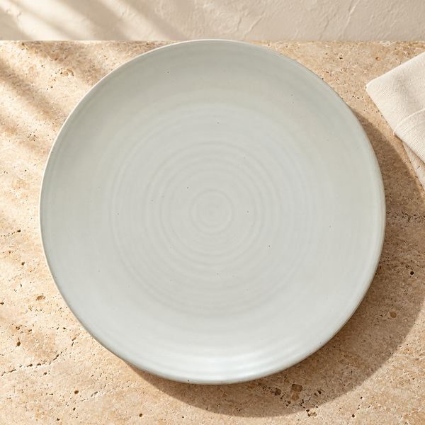 Matte White Stoneware Dinner Plate on a sunlit travertine counter