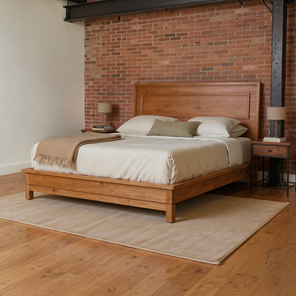 Honey Maple Wood Platform Bed with ivory bedding, an olive pillow and camel throw in a brick and steel loft bedroom with a flat oatmeal rug.