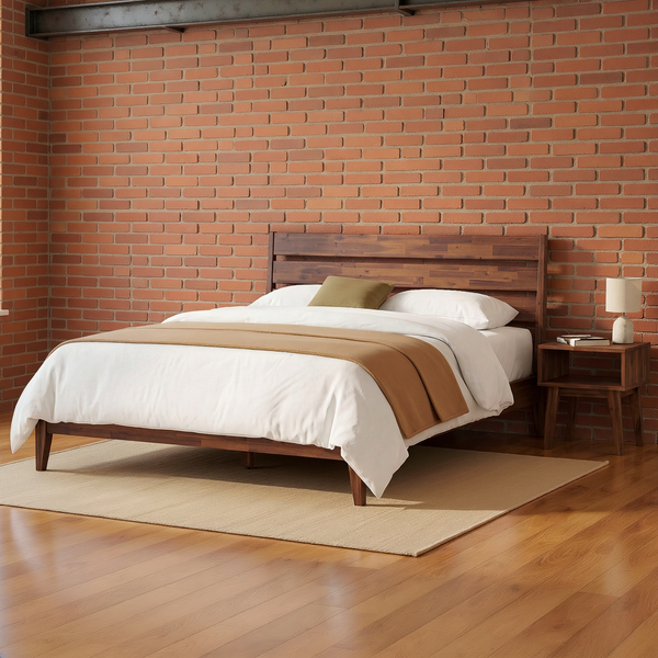 Wood platform bed and matching open-shelf nightstand against a brick wall with ivory bedding, an olive cushion, a camel throw and a flat oatmeal rug.
