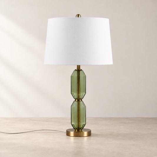 Faceted Green Glass Table Lamp on a warm neutral concrete surface