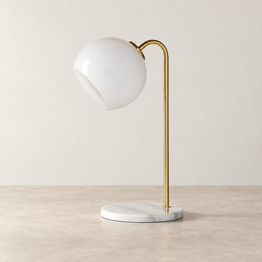 Globe Shade Brass Table Lamp on a warm neutral concrete surface
