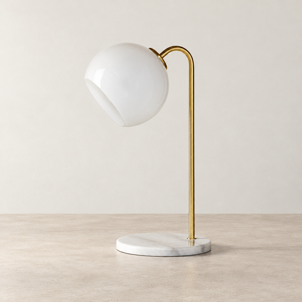 Globe Shade Brass Table Lamp on a warm neutral concrete surface